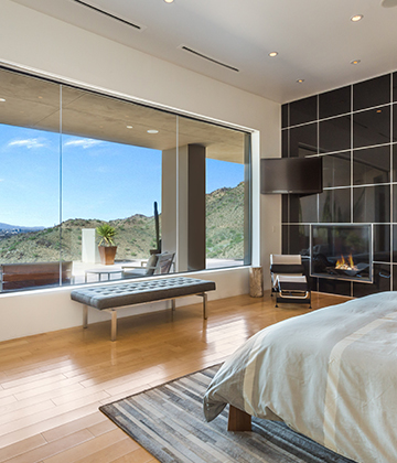 Home Remodeling in Scottsdale, AZ view of a master bedroom and picture windows with modern fireplace